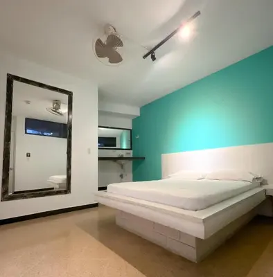 a bedroom with a large bed and a mirror at Hotel Natural Medellin in Medellín