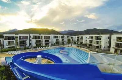 a resort with a large swimming pool in front of a building at Hermoso Apartasol, cerca al Parque Principal, Piscinas, Aire acondicionado in Santa Fe de Antioquia