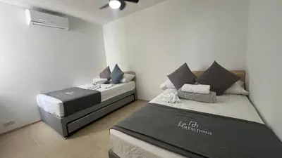 a bedroom with two beds in a room at Hermoso Apartasol, cerca al Parque Principal, Piscinas, Aire acondicionado in Santa Fe de Antioquia