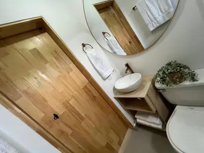 a bathroom with a sink and a mirror and a toilet at Hermoso Apartasol, cerca al Parque Principal, Piscinas, Aire acondicionado in Santa Fe de Antioquia