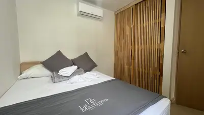 a bedroom with a bed with two pillows at Hermoso Apartasol, cerca al Parque Principal, Piscinas, Aire acondicionado in Santa Fe de Antioquia
