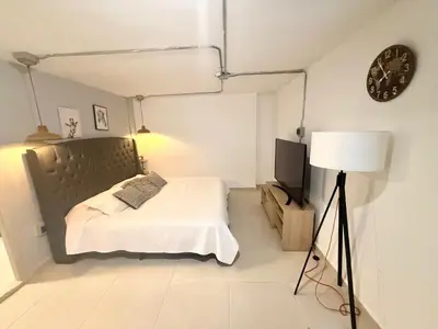 a bedroom with a bed and a lamp and a clock at Apartamento de lujo Poblado in Estación El Salto