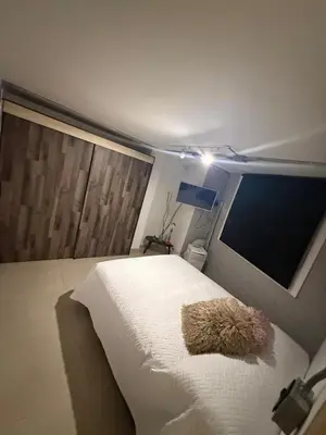 a teddy bear laying on a bed in a bedroom at Apartamento de lujo Poblado in Estación El Salto