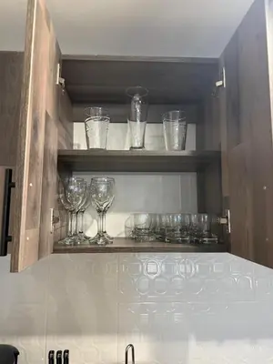a row of wine glasses on shelves in a kitchen at Apartamento de lujo Poblado in Estación El Salto