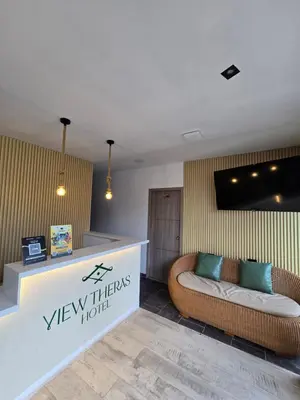a lobby with a couch and a tv on the wall at View Theras Hotel in Doradal