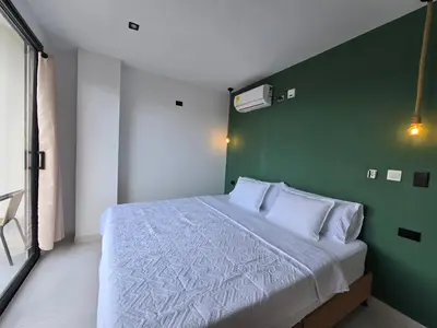 a bedroom with a large bed with a green wall at View Theras Hotel in Doradal
