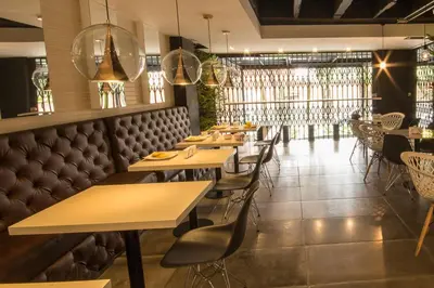 a row of tables and chairs in a restaurant at Lleras Green Hotel in Medellín