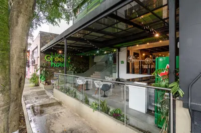 a restaurant with a balcony with a table and chairs at Lleras Green Hotel in Medellín