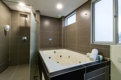 a large bathroom with a tub and a window at Lleras Green Hotel in Medellín