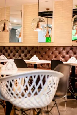 a dining room with a table and chairs and lights at Lleras Green Hotel in Medellín