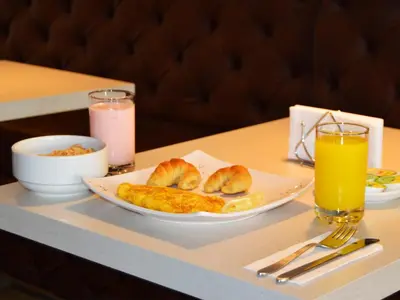 a table with a plate of pastries and a glass of orange juice at Lleras Green Hotel in Medellín