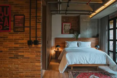 a bedroom with a bed and a brick wall at 10-36 Dieztreintayseis Short & Long Term Living in Medellín