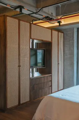 a bedroom with a tv and a bed with sliding doors at 10-36 Dieztreintayseis Short & Long Term Living in Medellín
