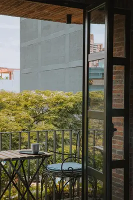 a table and chairs on a balcony with a table and a window at 10-36 Dieztreintayseis Short & Long Term Living in Medellín