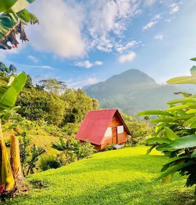 a barn with a red roof on a green field at Hotel Cabañas Villa Loe Jardín in Jardin