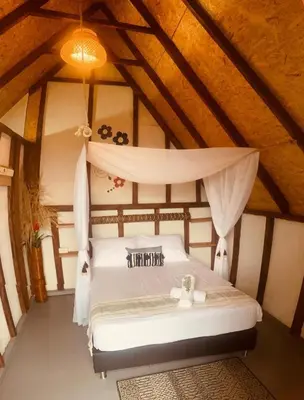 a bedroom with a white bed in a attic at Hotel Cabañas Villa Loe Jardín in Jardin