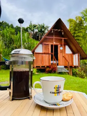 a cup of coffee sitting on a table next to a coffee at Hotel Cabañas Villa Loe Jardín in Jardin