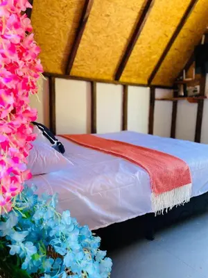 a bed with a red blanket and blue flowers at Hotel Cabañas Villa Loe Jardín in Jardin