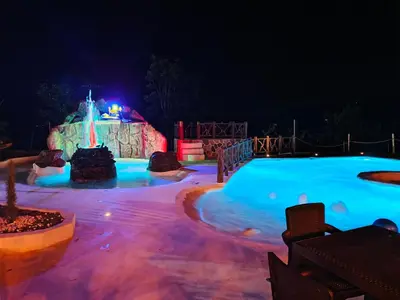a swimming pool at night with a water park at finca hotel ganbaru