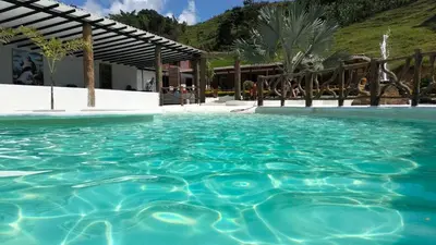 a pool of blue water in front of a building at finca hotel ganbaru