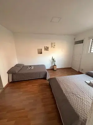 a bedroom with two beds and a wooden floor at Apartamento Rosa colonial in Medellín