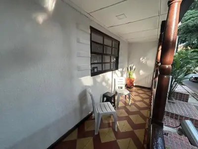 a porch with two chairs and a table and a window at Apartamento Rosa colonial in Medellín