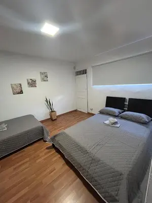a bedroom with two beds and a wooden floor at Apartamento Rosa colonial in Medellín
