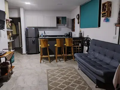 a living room with a couch and a kitchen at Apartamento con jacuzzi in Santa Fe de Antioquia
