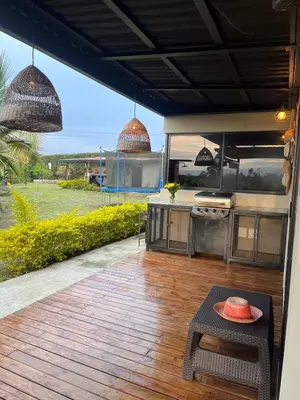 an outdoor kitchen with a grill and a table at Finca de Lujo en Rionegro -30 min Airport -1 hr Guatapé in Rionegro