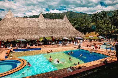 a group of people in a pool at a resort at Hotel Hacienda La Bonita in Amagá