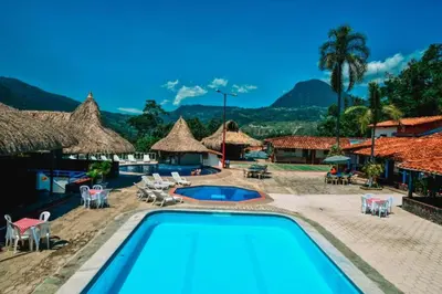 a pool at a resort with mountains in the background at Hotel Hacienda La Bonita in Amagá