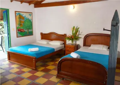 a bedroom with two beds in a room at Hotel Hacienda La Bonita in Amagá
