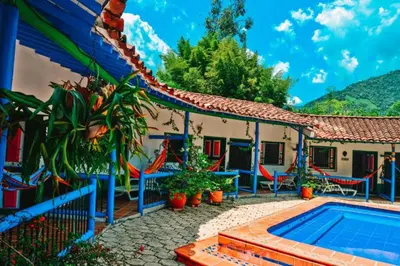 a house with a swimming pool in front of it at Hotel Hacienda La Bonita in Amagá