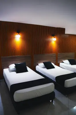 two beds in a room with two lights on the wall at Hotel Santorini la 70 in Medellín