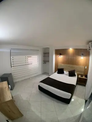 a bedroom with a large bed in a room at Hotel Santorini la 70 in Medellín