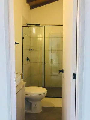a bathroom with a toilet and a glass shower at Apartamento en Rionegro in Rionegro