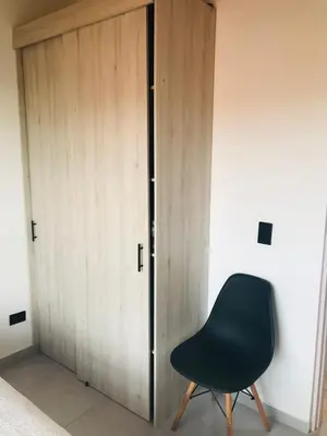 a black chair sitting next to a wooden door at Apartamento en Rionegro in Rionegro