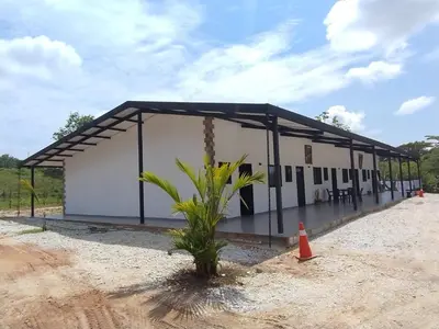 a large white building with a black roof at JyM apartaestudios in Doradal