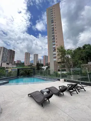 a pool with two lounge chairs and a building at Huge Apartment for families at Poblado in Medellín