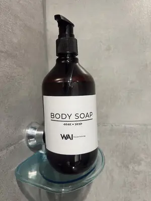 a bottle of body soap sitting on a glass holder at SUITE DE LUJO FARO con Aire Acondicionado y Coworking in Medellín
