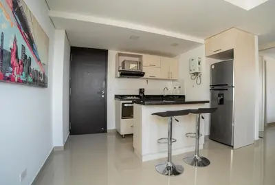a kitchen with a refrigerator and a counter with stools at Cozy apt in Poblado The best area Great view in Medellín