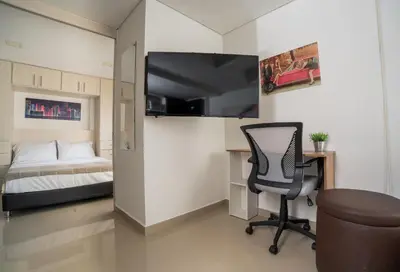 a bedroom with a bed and a desk and a chair at Cozy apt in Poblado The best area Great view in Medellín