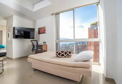 a living room with a large window and a couch at Cozy apt in Poblado The best area Great view in Medellín