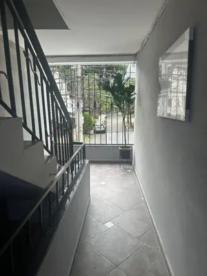 a hallway of a building with a staircase and a window at Apartamentos Acogedores Laureles in Medellín