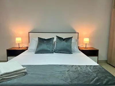 a bedroom with a bed with pillows and two lamps at Comfortable and equipped apartment 5 minutes from the 70 Laureles in Medellín