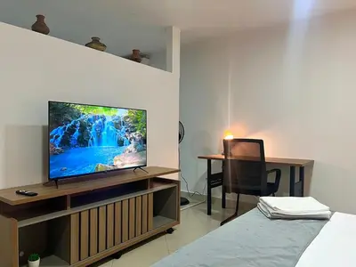 a living room with a television on a wooden entertainment center at Comfortable and equipped apartment 5 minutes from the 70 Laureles in Medellín