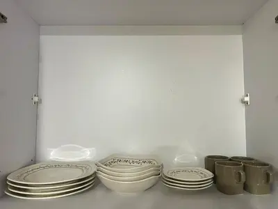 three plates and pans sitting on a shelf at Comfortable and equipped apartment 5 minutes from the 70 Laureles in Medellín