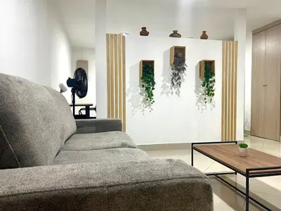 a living room with a couch and a table at Comfortable and equipped apartment 5 minutes from the 70 Laureles in Medellín