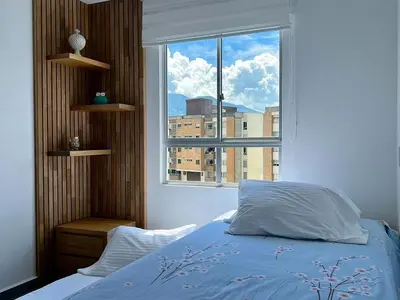 a bedroom with a bed and a large window at Moderno Apartamento Sabaneta - Century Tower II in Sabaneta