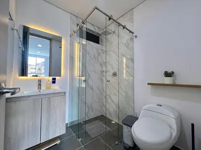 a bathroom with a shower and a toilet and a sink at Moderno Apartamento Sabaneta - Century Tower II in Sabaneta